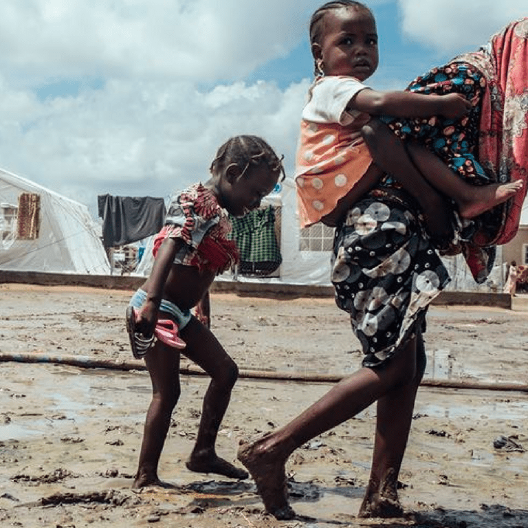 Children walk through the mud in a displaced persons camp in Maiduguri in northeast Nigeria.