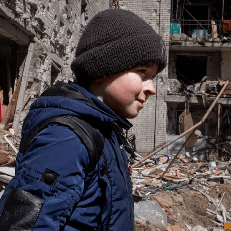 A ten-year-old boy walks in the courtyard in front of his family’s apartment in central Chernihiv, Ukraine, which was destroyed in an air strike.