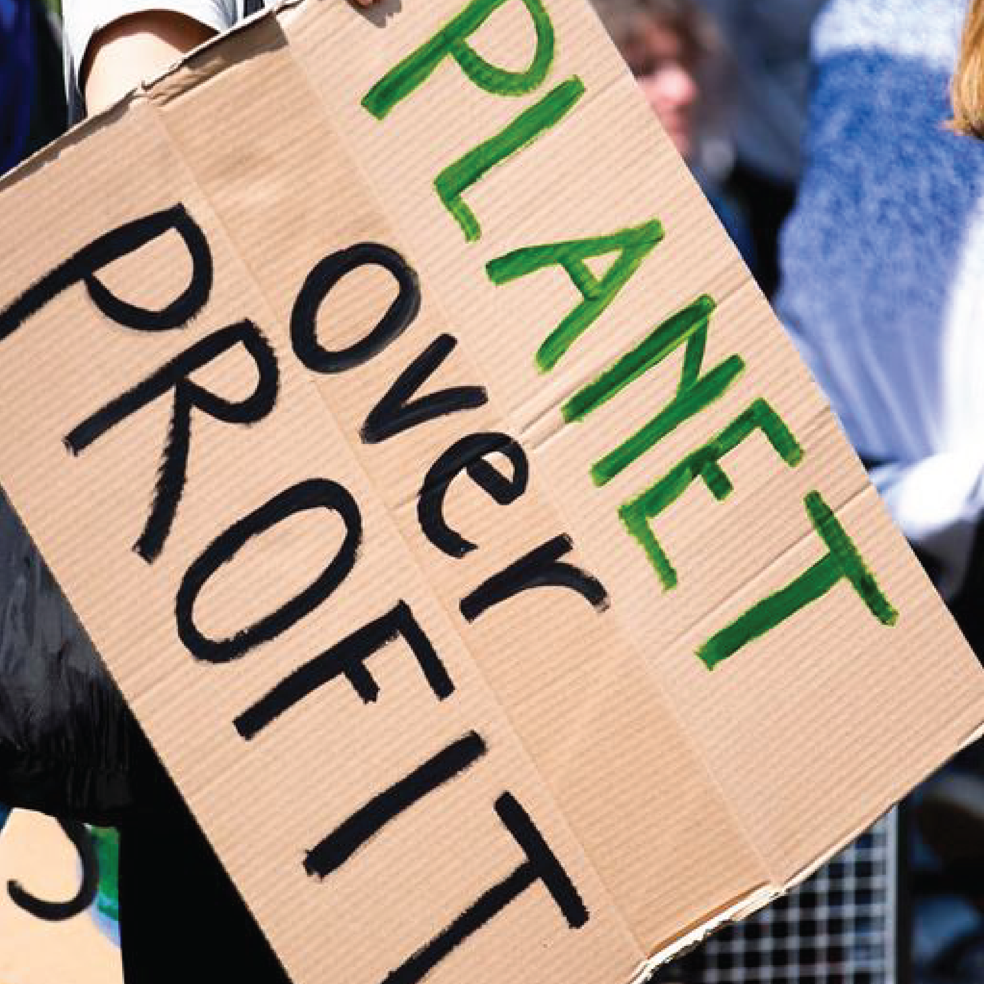 A sign board with text Planet over Profit.