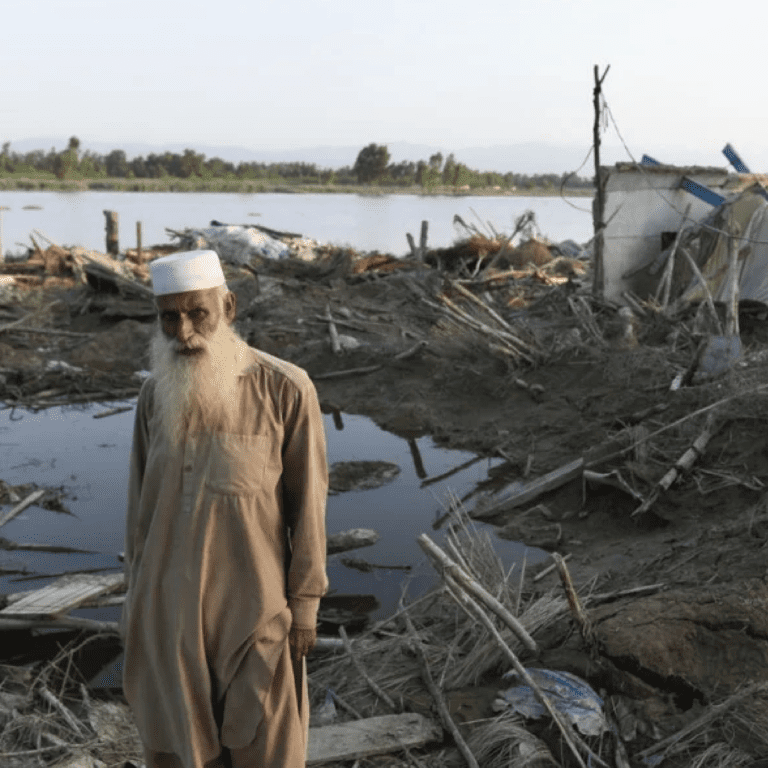 Afghan refugee Bahadur, 60, stands amid the wreckage of his home after monsoon flooding in Khyber Pakhtunkhwa Province, Pakistan. © UNHCR/Usman Ghani