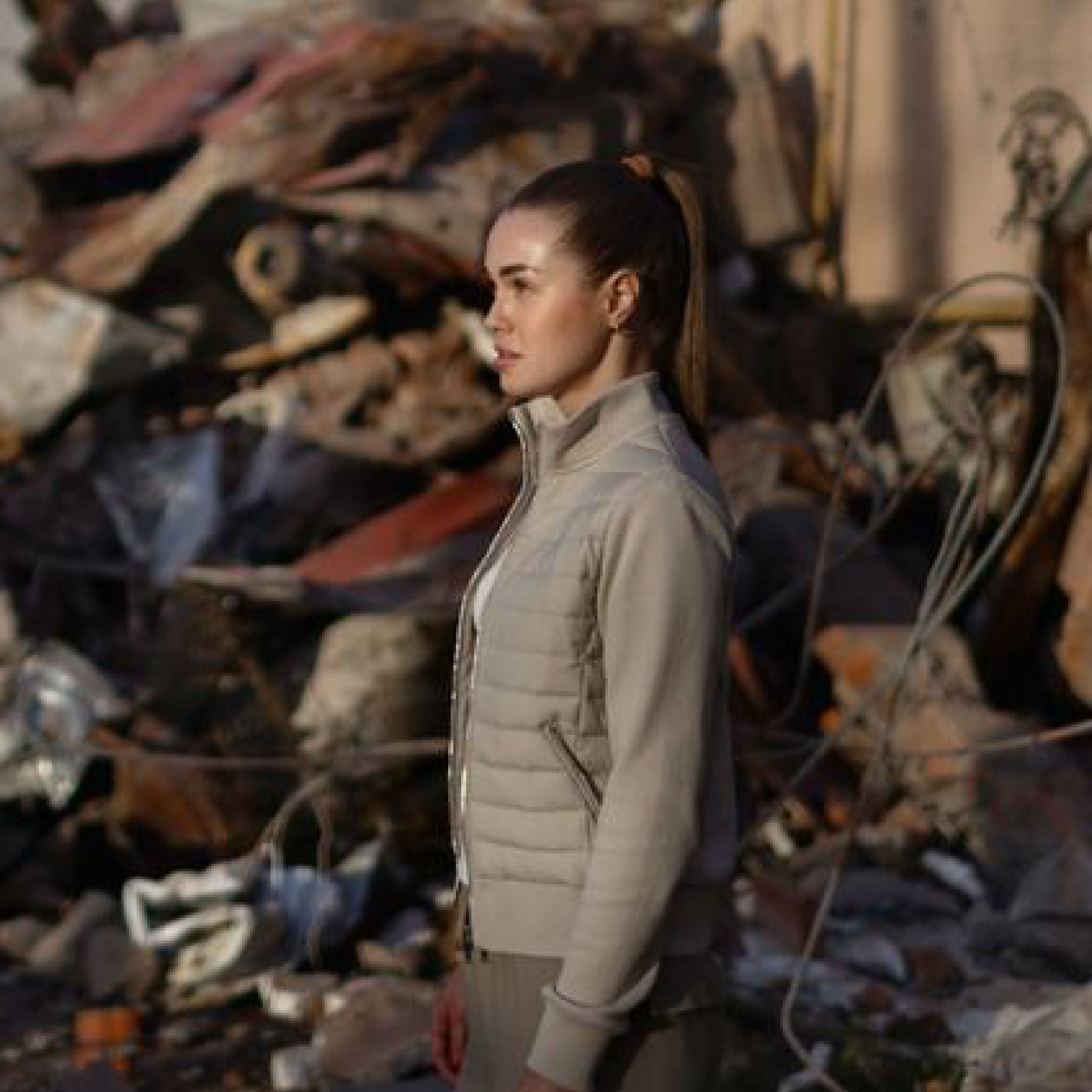 A young Ukrainian woman walks amidst the ruins of her grandparents’ home in Irpin.