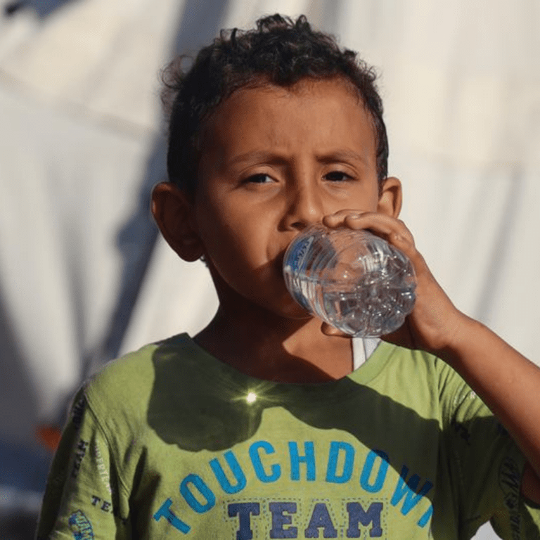 A five-year-old boy drinks bottled water delivered by UNICEF in the Khan Younis camp in Gaza..