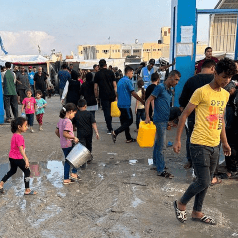 People displaced by the conflict in Gaza collect water in the Khan Younis refugee camp.