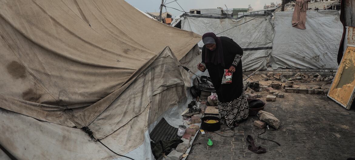 Pictured here, a woman prepares food in Gaza City after a night of rain and wind.